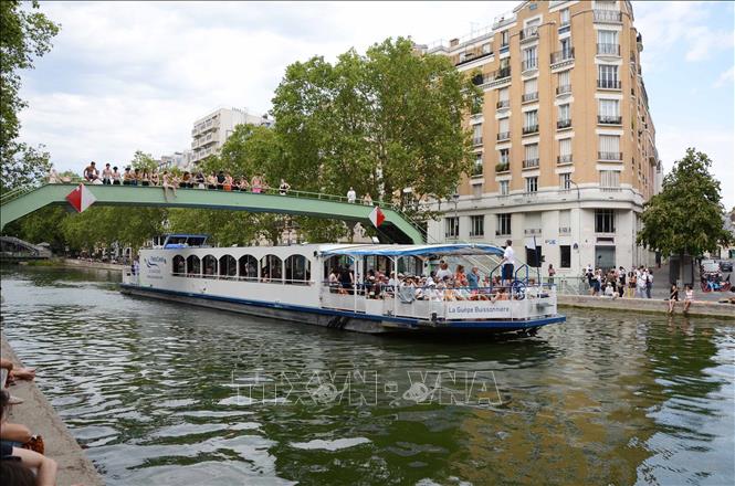 Một du thuyền chở khách đi qua kênh Saint-Martin trong ngày nắng nóng tại Paris, ngày 13/7/2026. Ảnh: Khánh Toàn - PV TTXVN tại Pháp
