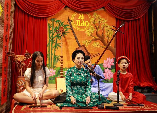 Các bạn trẻ trải nghiệm nghệ thuật ca trù truyến thống. Ảnh: Khánh Hoà - TTXVN