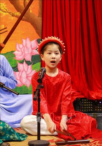 Em Nguyễn Bảo Ngọc (8 tuổi, Hà Nội) - thành viên nhí của Câu lạc bộ Ca trù Bích Câu tham gia biểu diễn cùng các nghệ nhân. Ảnh: Khánh Hoà - TTXVN