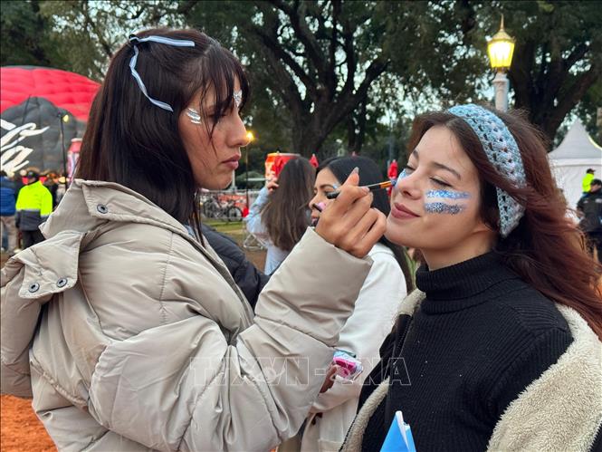 Người hâm mộ vẽ hình cờ Argentina lên mặt cổ vũ đội tuyển Ảnh: Diệu Hương, phóng viên TTXVN tại Buenos Aires
