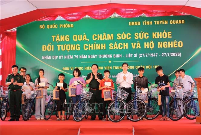Đại tướng Nguyễn Trọng Nghĩa thăm hỏi, động viên và trao tặng xe đạp cho học sinh trên địa bàn có hoàn cảnh khó khăn, nỗ lực vươn lên trong học tập. Ảnh: Hoàng Hiếu - TTXVN