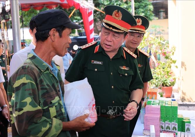 Đại tướng Nguyễn Trọng Nghĩa thăm hỏi đối tượng chính sách và hộ nghèo đang được khám, cấp phát thuốc miễn phí. Ảnh: Hoàng Hiếu - TTXVN