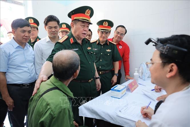 Đại tướng Nguyễn Trọng Nghĩa thăm hỏi đối tượng chính sách và hộ nghèo đang được khám, cấp phát thuốc miễn phí. Ảnh: Hoàng Hiếu - TTXVN