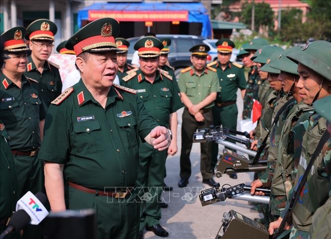 Đại tướng Nguyễn Trọng Nghĩa thăm hỏi, động viên thành viên Công ty TNHH xử lý bom, mìn, vật nổ 319 (Bộ Quốc phòng) đang làm nhiệm vụ tại xã Thanh Thuỷ. Ảnh: Hoàng Hiếu - TTXVN