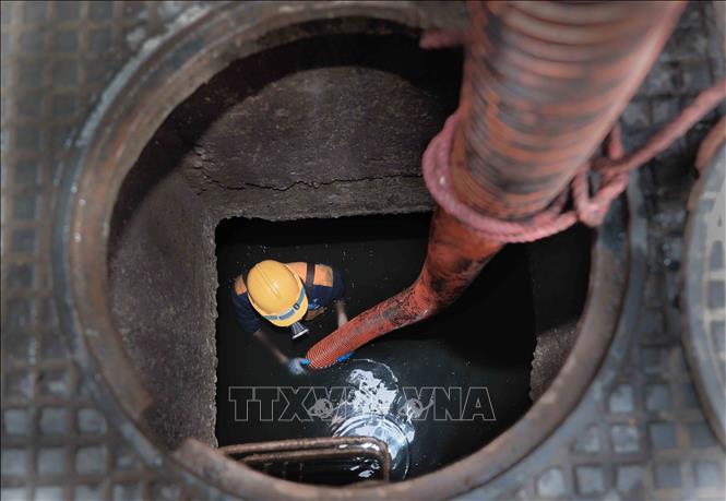Thi công trong môi trường độc hại, tiềm ẩn nhiều nguy cơ, những người công nhân thầm lặng góp phần xây dựng Thủ đô ngày càng sạch đẹp, hiện đại. Ảnh: Phan Phương – TTXVN