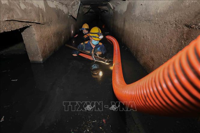 3 năm kinh nghiệm, anh Nguyễn Duy Thịnh (Tổ cơ giới 6, Công ty Thoát nước Hà Nội) ngày ngày vẫn miệt mài nhiều giờ dưới lòng kênh, bảo vệ tuyến thoát nước huyết mạch phía Tây Thủ đô. Ảnh: Phan Phương – TTXVN