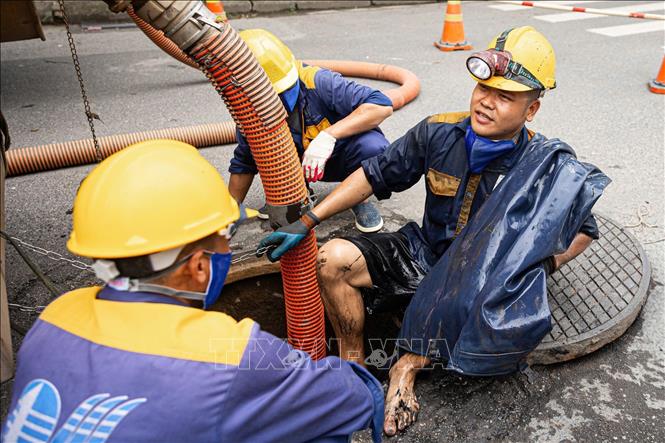 Kết thúc một ca làm thu gom rác dưới cống ngầm của các công nhân Công ty TNHH MTV Thoát nước Hà Nội. Ảnh: Tiến Long/TTXVN phát