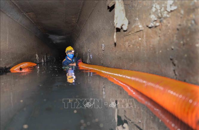 Xí nghiệp Thi công cơ giới xây lắp (Công ty Thoát nước Hà Nội) nạo vét tuyến cống Xuân Tảo (1,5x2m) bằng cơ giới kết hợp thủ công. Với 5 tổ thực hiện, công nhân trực tiếp xuống cống vận hành vòi hút, xử lý khoảng 1.000m³ bùn mỗi đợt, đảm bảo thoát nước mùa mưa. Ảnh: Phan Phương – TTXVN