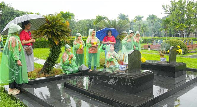 Sáng 18/7, dù thời tiết không thuận lợi nhưng đông đảo người dân địa phương và du khách đã đến nghĩa trang A1 để thắp hương tưởng nhớ, tri ân các Anh hùng liệt sĩ. Ảnh: Phan Quân - TTXVN

