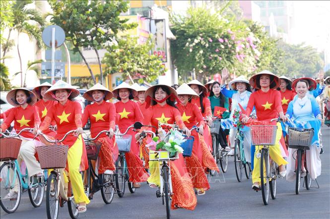 Các hội viên phụ nữ tỉnh Khánh Hòa trong trang phục áo dài diễu hành xe đạp qua tuyến phố Trần Phú. Ảnh: Phan Sáu - TTXVN