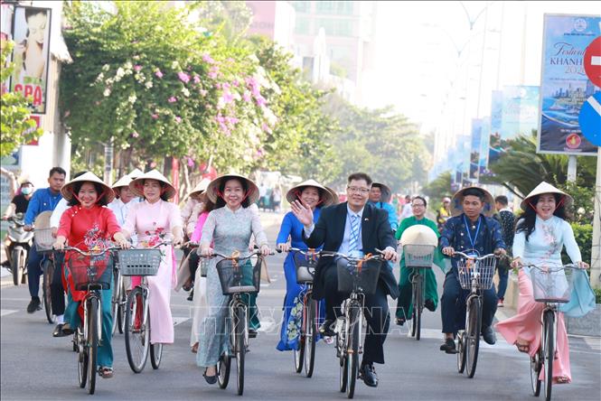 Các nữ trí thức, lãnh đạo sở ngành cùng tham gia đạp xe diễu hành áo dài trên đường phố Nha Trang. Ảnh: Phan Sáu - TTXVN