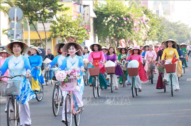 Những tà áo dài rực rỡ sắc màu tung bay trên cung đường biển Nha Trang. Ảnh: Phan Sáu - TTXVN