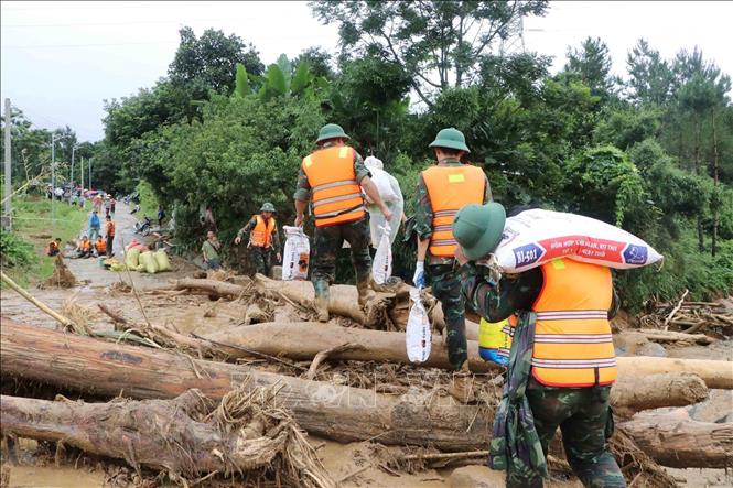 Các lực lượng cứu hộ của tỉnh Lai Châu giúp người dân Mường Than di dời tài sản đến nơi an toàn. Ảnh: Nguyễn Oanh - TTXVN