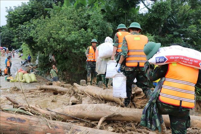 Các lực lượng cứu hộ của tỉnh Lai Châu giúp người dân Mường Than di dời tài sản đến nơi an toàn. Ảnh: Nguyễn Oanh - TTXVN