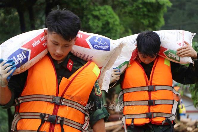 Các lực lượng cứu hộ của tỉnh Lai Châu giúp người dân Mường Than di dời tài sản đến nơi an toàn. Ảnh: Nguyễn Oanh - TTXVN