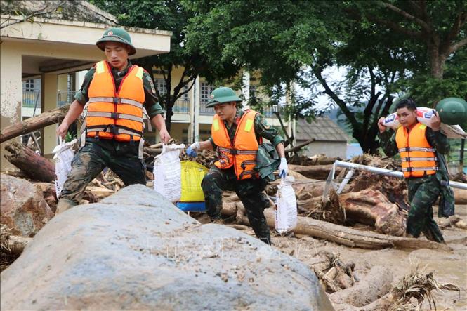 Các lực lượng cứu hộ của tỉnh Lai Châu giúp người dân Mường Than di dời tài sản đến nơi an toàn. Ảnh: Nguyễn Oanh - TTXVN