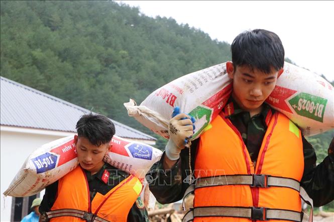 Các lực lượng cứu hộ của tỉnh Lai Châu giúp người dân Mường Than di dời tài sản đến nơi an toàn. Ảnh: Nguyễn Oanh - TTXVN