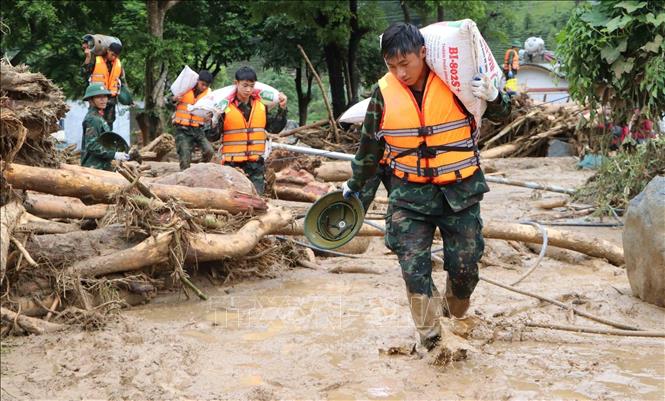 Các lực lượng cứu hộ của tỉnh Lai Châu giúp người dân Mường Than di dời tài sản đến nơi an toàn. Ảnh: Nguyễn Oanh - TTXVN