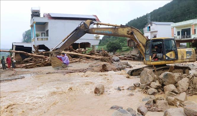 Hỗ trợ người dân di chuyển đến nơi an toàn. Ảnh: Nguyễn Oanh - TTXVN