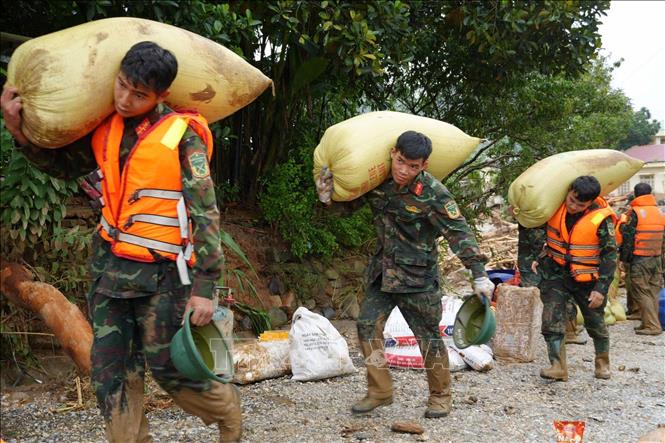 Các lực lượng cứu hộ của tỉnh Lai Châu giúp người dân Mường Than di dời tài sản đến nơi an toàn. Ảnh: Nguyễn Oanh - TTXVN