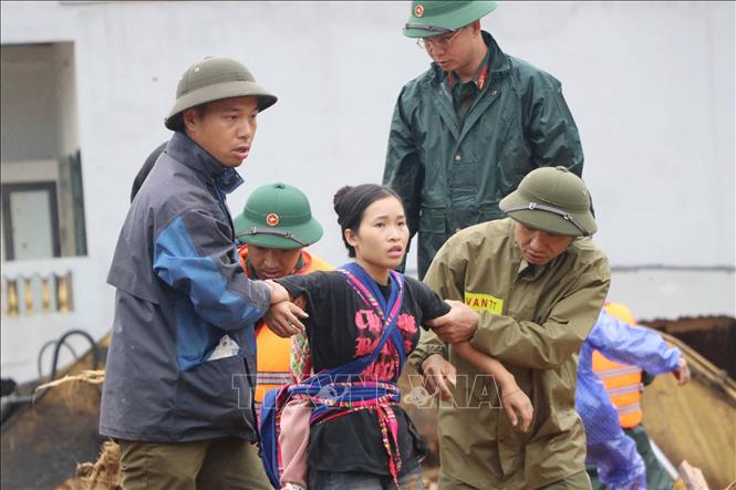 Các lực lượng cứu hộ giúp người dân di chuyển đến nơi an toàn. Ảnh: Nguyễn Oanh - TTXVN