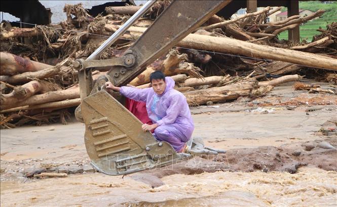 Hỗ trợ người dân di chuyển đến nơi an toàn. Ảnh: Nguyễn Oanh - TTXVN