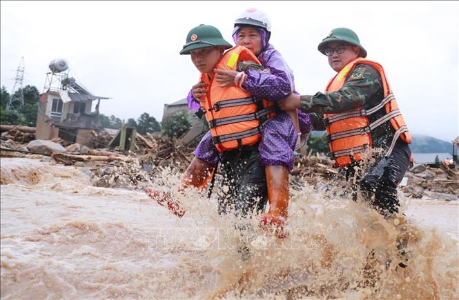 Lực lượng Công an cùng Quân đội đưa người dân ra khỏi nơi nguy hiểm tại khu vực xảy ra lũ quét xã Mường Than, tỉnh Lai Châu. Ảnh: Quý Trung – TTXVN