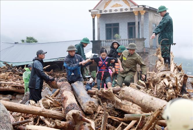Lực lượng Công an cùng Quân đội đưa người dân ra khỏi nơi nguy hiểm tại khu vực xảy ra lũ quét xã Mường Than, tỉnh Lai Châu. Ảnh: Quý Trung – TTXVN