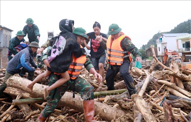 Lực lượng Công an cùng Quân đội đưa người dân ra khỏi nơi nguy hiểm tại khu vực xảy ra lũ quét xã Mường Than, tỉnh Lai Châu. Ảnh: Quý Trung – TTXVN