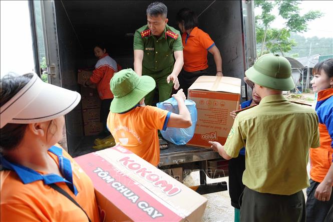 Các đoàn từ thiện tiếp tế nhu yếu phẩm tại Mường Than. Ảnh: Nguyễn Oanh - TTXVN