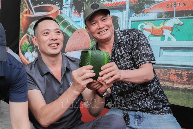 Du khách hào hứng trải nghiệm gói bánh chưng, giã bánh giầy, làm giò chả, qua đó thêm thấu hiểu đạo lý 