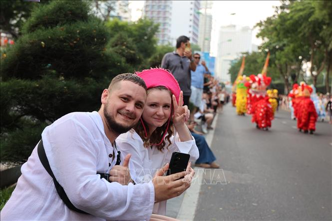Du khách ghi lại những khoảnh khắc ấn tượng trong đêm diễu hành Carnival. Ảnh: Đặng Tuấn - TTXVN