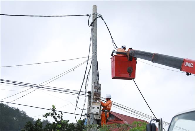 Công ty Điện lực Lai Châu huy động cán bộ, công nhân kỹ thuật, phương tiện máy móc, trang thiết bị tập trung khắc phục hệ thống lưới điện. Ảnh: Quý Trung - TTXVN