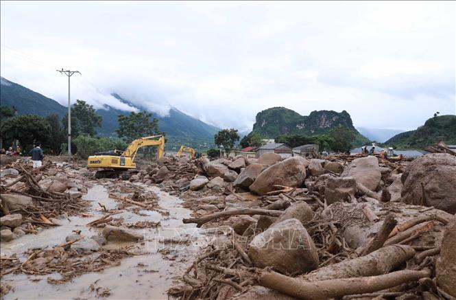 Phương tiện máy móc khơi thông, uốn dòng chảy để nhanh chóng khắc phục giao thông trên tuyến Quốc lộ 32. Ảnh: Quý Trung - TTXVN