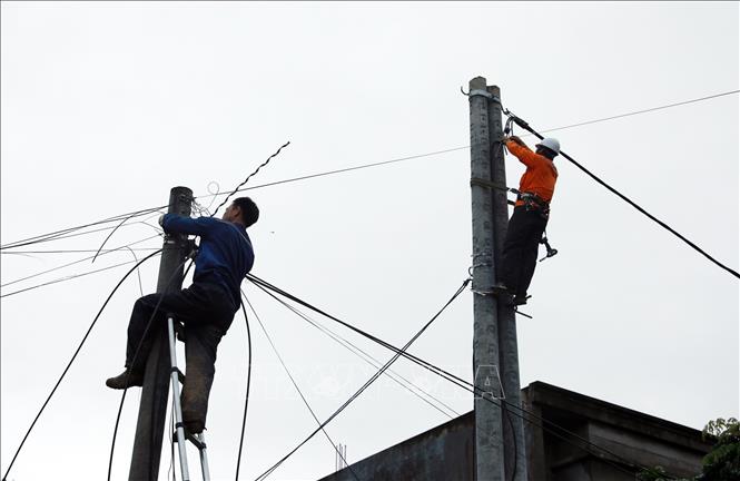 Nhà mạng viễn thông cùng công nhân Công ty điện lực Lai Châu tập trung khắc phục hạ tầng, góp phần sớm ổn định cuộc sống người dân sau lũ dữ. Ảnh: Quý Trung - TTXVN