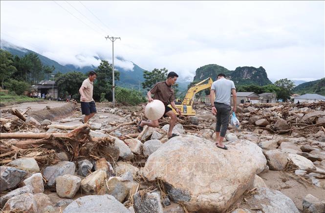 Nước lũ rút và trời đã ngớt mưa, người dân trở về nhà. Ảnh: Quý Trung - TTXVN