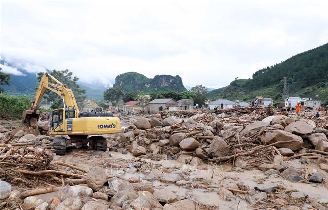 Phương tiện máy móc khơi thông, nắn dòng chảy để nhanh chóng khắc phục giao thông trên tuyến Quốc lộ 32. Ảnh: Quý Trung - TTXVN